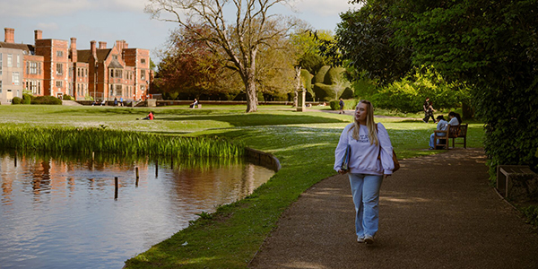 a university of opportunity scholar walking by the York campus lake
